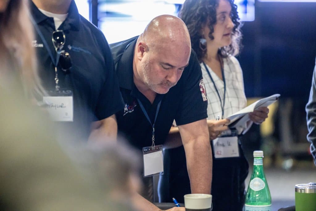 Man leaning over table looking at documents